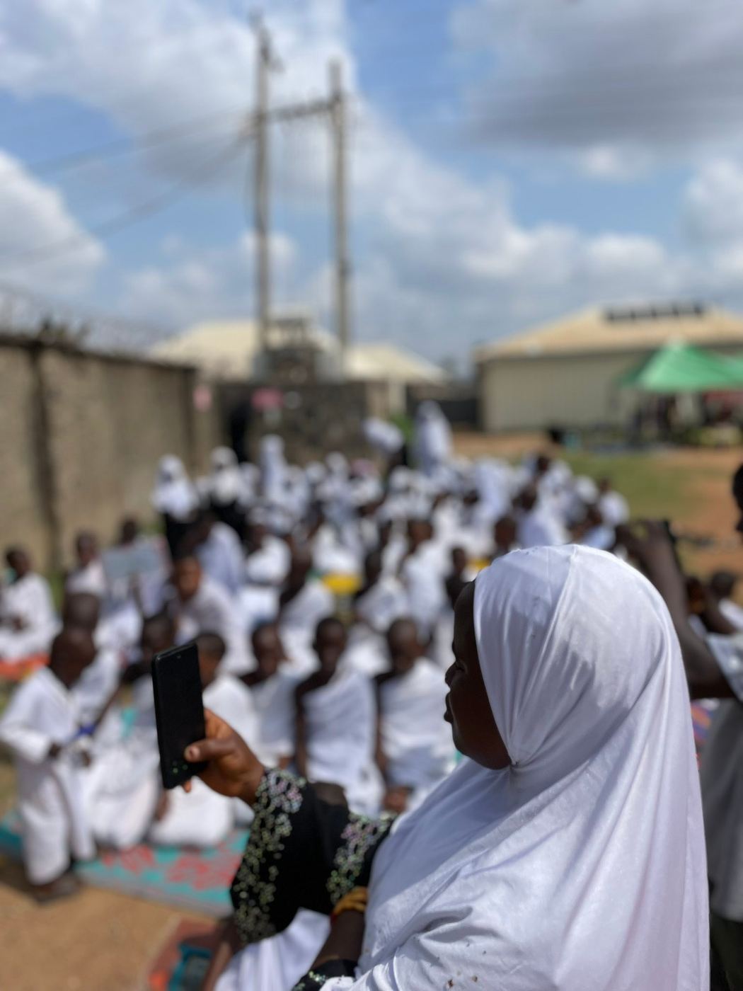 A teacher standing before learners dressed for a Hajj learning activity