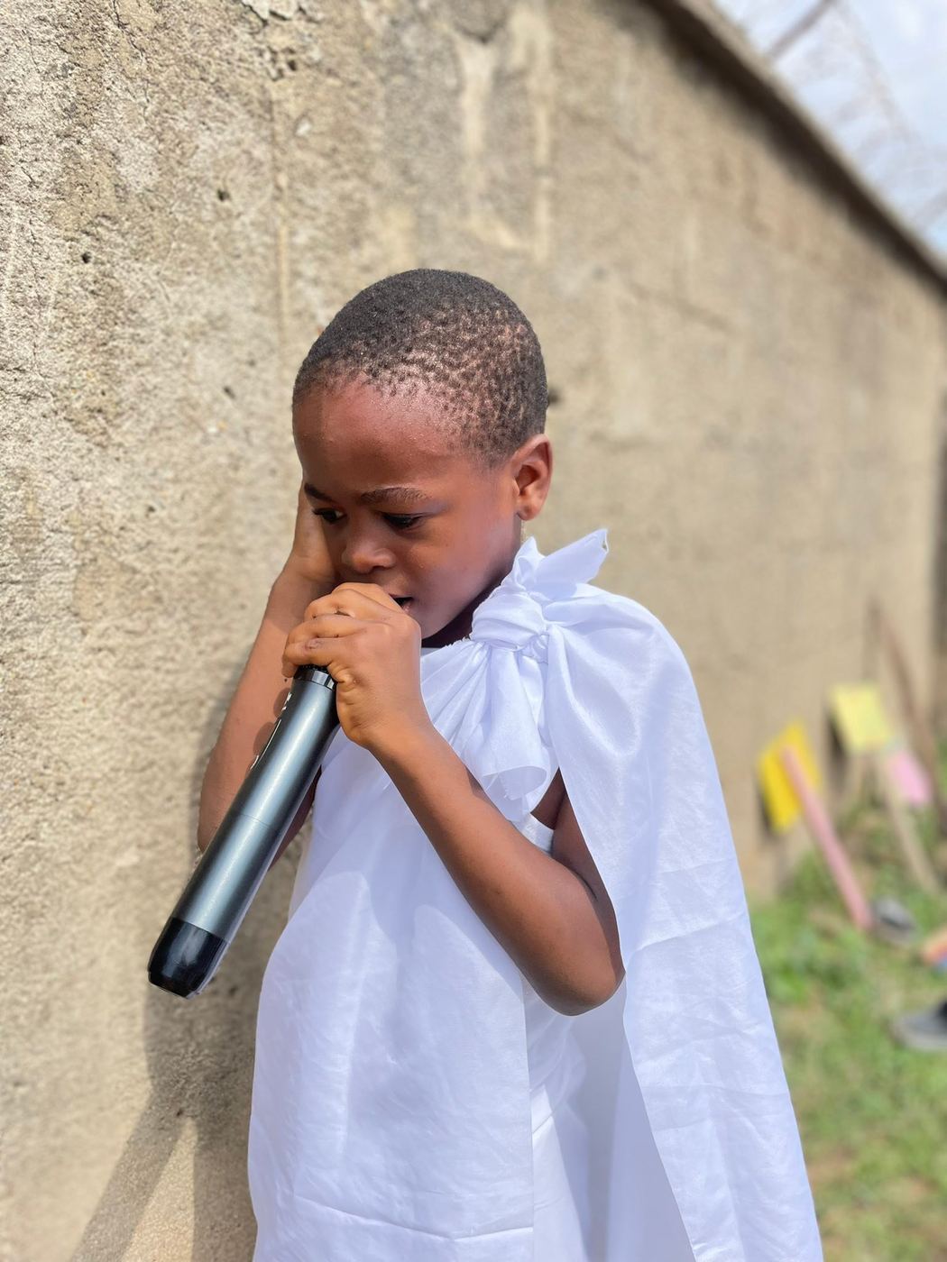 A young learner speaking into a microphone during a Hajj-themed school activity