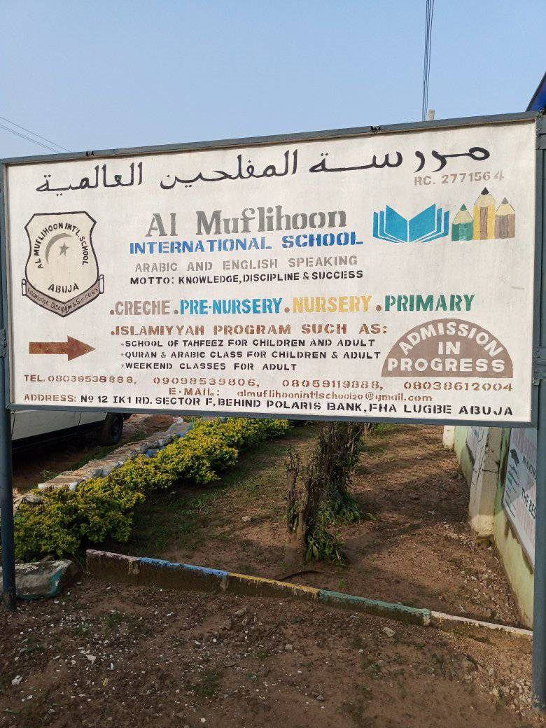 The Al-Muflihoon International School signboard showing the school name and address